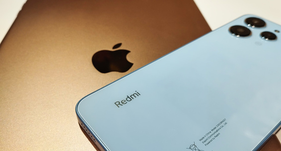 Gold iPad and Xiaomi Redmi 12 Sky Blue color. Close-up. Concept of Confrontation between Apple and Xiaomi. Stock editorial photo. 16.10.2023 Ukraine. Kyiv