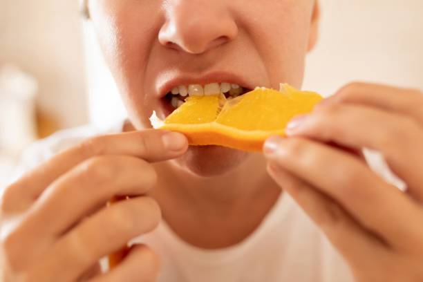 istock woman bites an orange while on a diet 1741728679