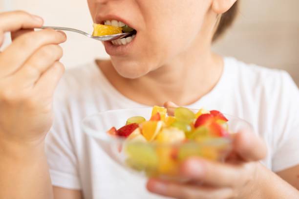 istock woman eating fruit during snack 1741728693