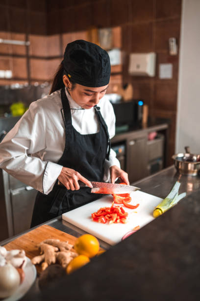 istock Asian Chef Cuts Red Pepper for a Dish with Care 1741732634