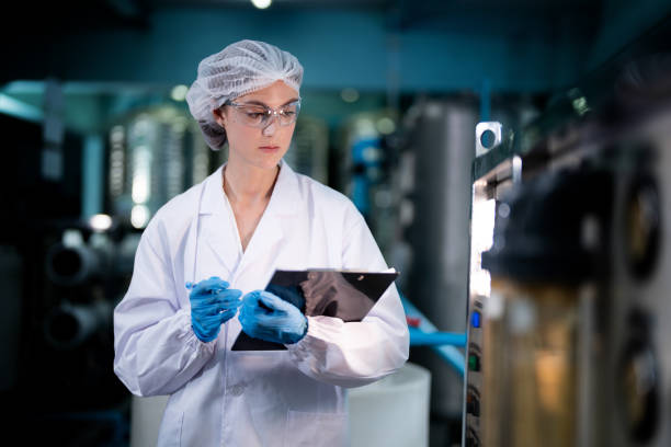 istock scientist worker checking the quality of Reverse osmosis machine system at the industrial factory. Female worker recording data at the control panel with measure pressure for recycle portable plant. 1741733734