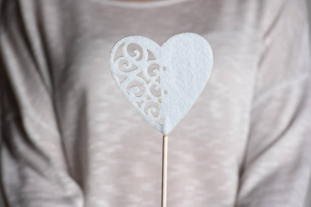 Decorative wooden shape of a white heart with sticks on a white background. A full frame image that symbolizing love and purity