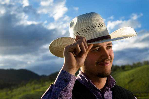 istock Cowboy:  Young wrangler tipping his hat.  Rocky Mountains in background. 174176216