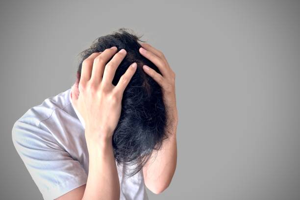 Office worker man holding his head A man holding his head and looking depressed head in hands stock pictures, royalty-free photos & images