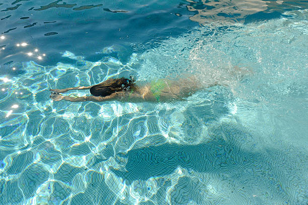 istock Girl swimming in a pool under water 174178477