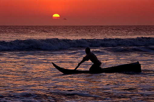 Peruvian indigenous people fishing at sunset on reed boat Huanchaco beach Peru