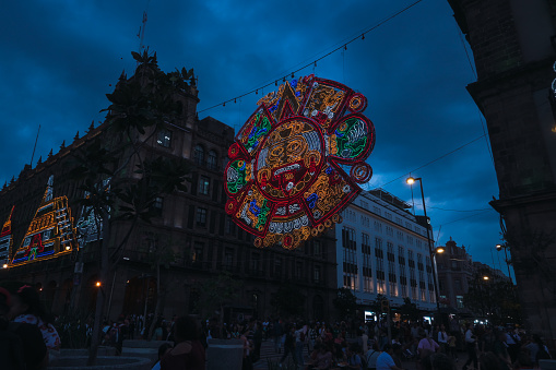 Decorations at the entrance to the zocalo in Mexico City for the celebration of the independence, decoration and lighting with pre-Hispanic motifs, colorful aztec calendar