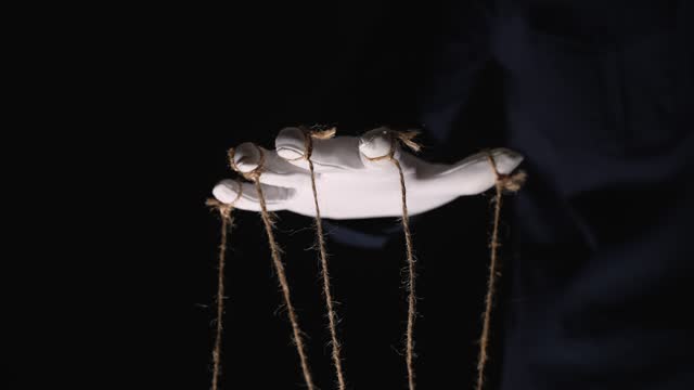 Manipulator hands in white gloves with ropes on fingers