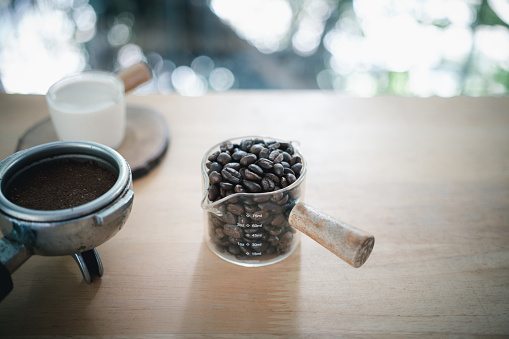 istock Portafilter with tamper and roasted coffee beans in a glass and scene of natural light. 1741835212