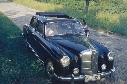 Baden Württemberg, Germany, 1964. Driving break on a country road during a weekend trip. Also: passenger.