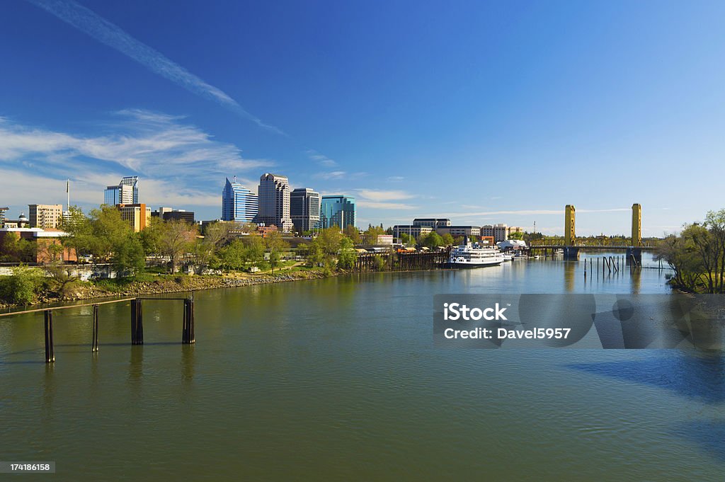 Sacramento skyline, riverboat, bridge, and river, wide angle view Downtown Sacramento skyline to the left and a Riverboat and Tower Bridge to the right, and the Sacramento River in the foreground, wide angle view. Sacramento Stock Photo