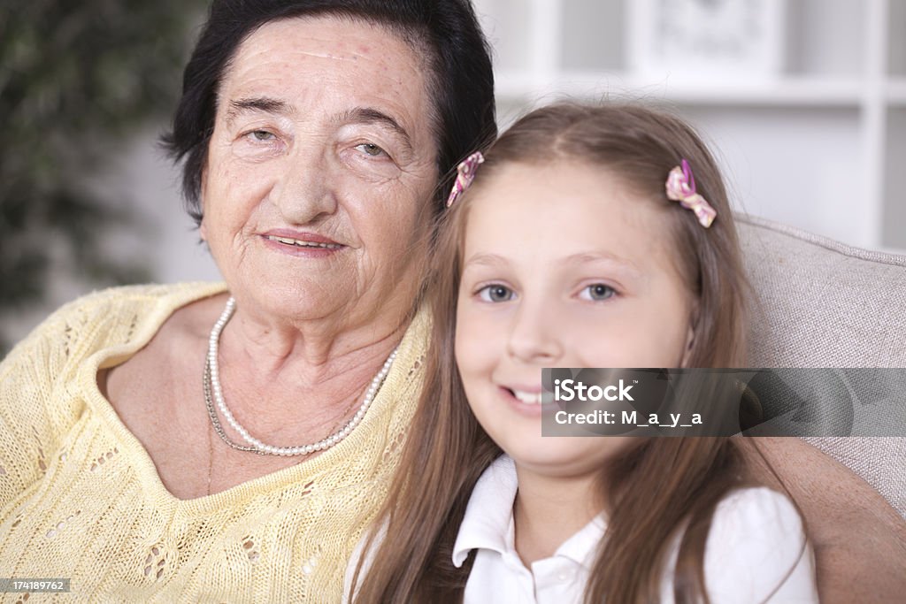 Grandmother and great-granddaughter. Grandmother  hugging her great-granddaughter. Focus is on senior women 70-79 Years Stock Photo