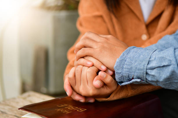 Casal está orando juntos, mãos em oração juntos sobre uma Bíblia Sagrada aberta. Crise da vida cristã oração a Deus. - foto de acervo