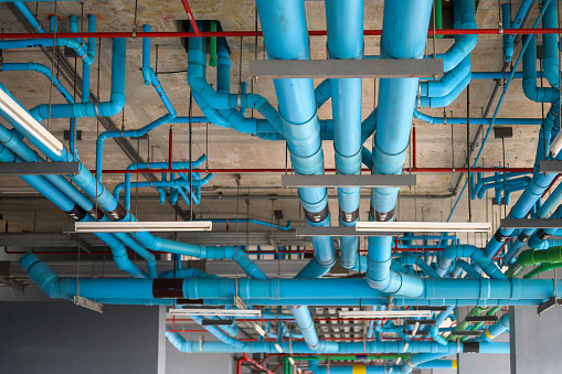 Fire protection sprinkler system with red pipes is placed to hanging from the ceiling