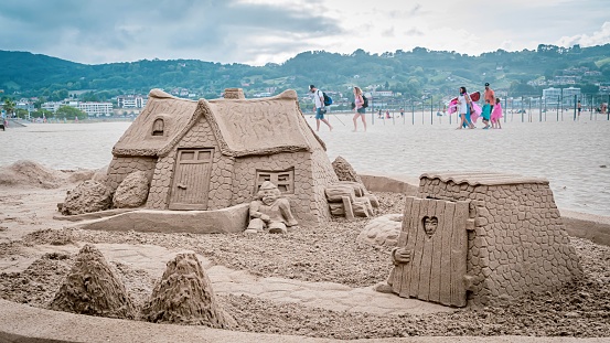 Hendaye, France – August 12, 2020: This image shows a large sand castle on a beach, with a house structure in the center