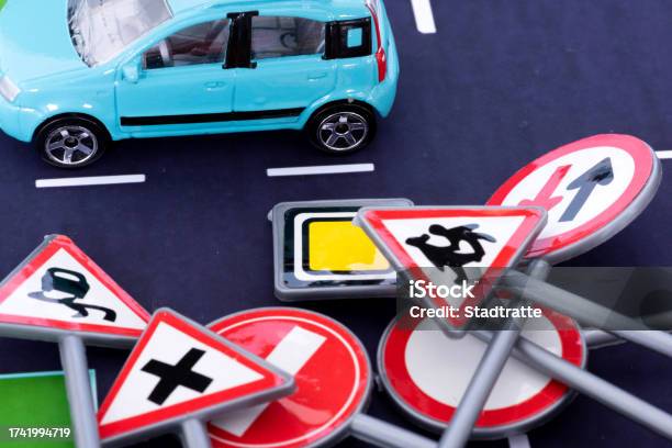 Ein Auto Auf Der Straße Und Verschiedene Verkehrsschilder Stock Photo - Download Image Now