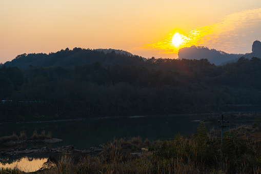 The sun setting down behind the distant mountains in Wuyishan, Fijian, China. Copy space for text, horizontal
