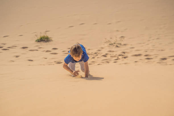 istock Boy overcomes difficulties and aspires to the purpose and dream. Boy overcomes difficulties in life as if in a desert 1742006822