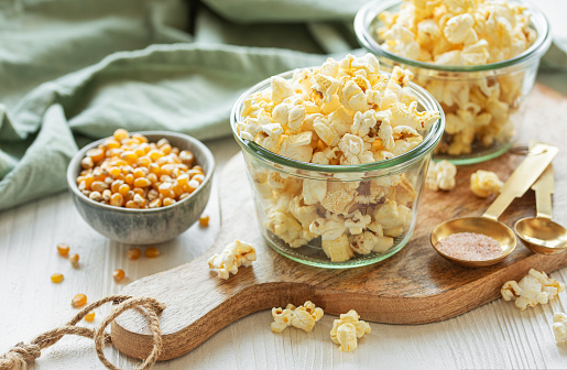 Popcorn in a bowl. Wood background