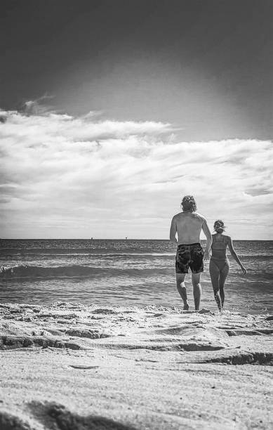 istock Couple Running on Beach Into Water 1742081112