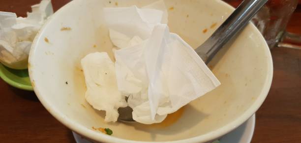 istock Leftover food in a bowl containing used tissue and a spoon 1742087679