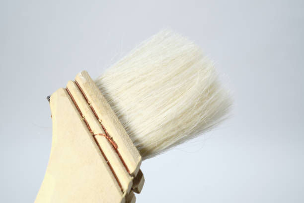 A course deck brush for cleaning patio furniture lying on the edge of a balcony.