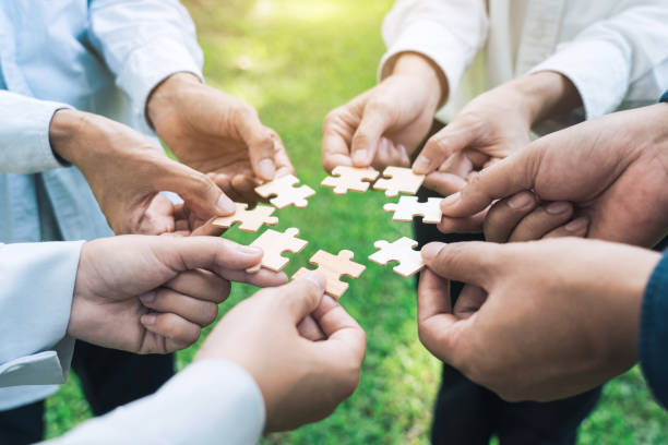 istock group of business people assembling jigsaw puzzle. The concept of cooperation, teamwork, help and support in business. 1742125603