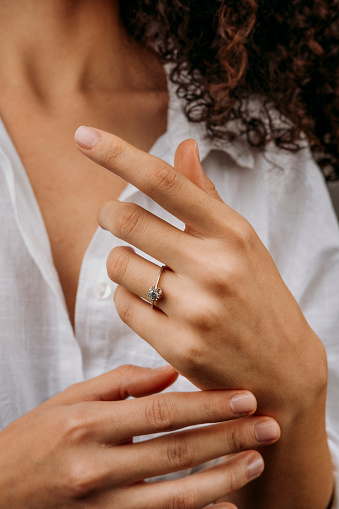 Close-up of an elegant engagement diamond ring on beautiful woman's finger. love and wedding concept. Like the split tone Instragram process.