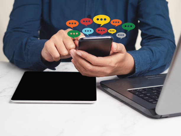 istock Close-up of hands using mobile phone with colorful chat icons on application communication digital 1742149005