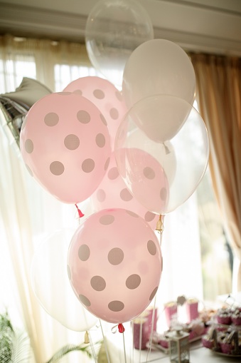 White and pink balloons by the candy bar on birthday party