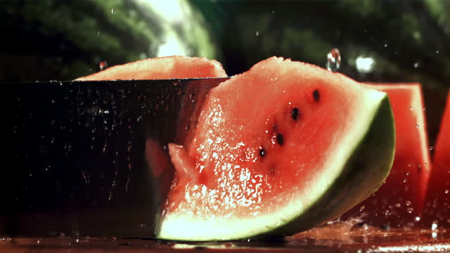 A knife cuts a watermelon. Filmed on a high-speed camera at 1000 fps.