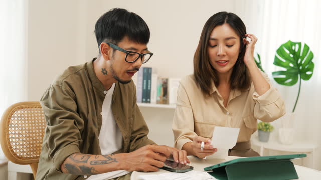 Young asian couple is calculating household and family expenses.