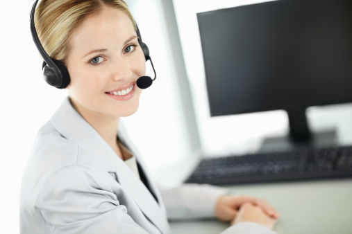 Friendly Service Agent Talking To Customer In Call Centre.