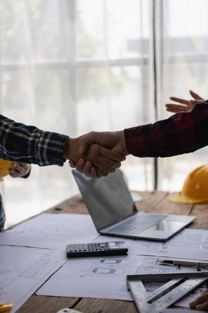 istock Construction worker and engineer holding hands Real estate concept: architect shaking hands with engineer or builder and successful meeting 1742206542