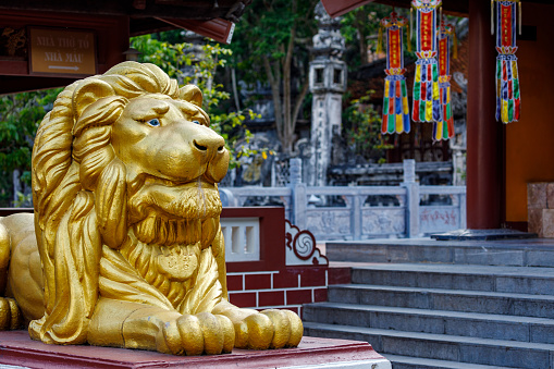 Old imperial lion sculpture in front of historical Forbidden City buildings.