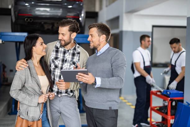istock Happy manager and young couple talking while using touchpad in auto repair shop. 1742217396