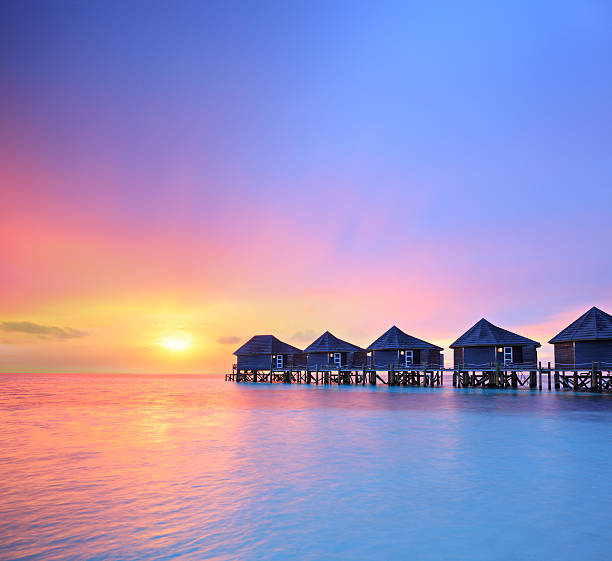 View of a beautiful sunset on a Maldives island and water villas, shot with a tilt and shift lens
