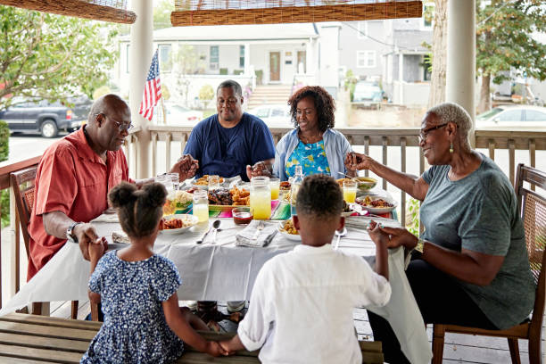Black family saying grace before meal in Rockaway Beach