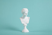 a white venus bust on a vivid turquoise background.
