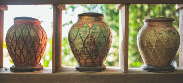 istock Ancient-style pottery jars are lined up on wooden shelves. 1742230576