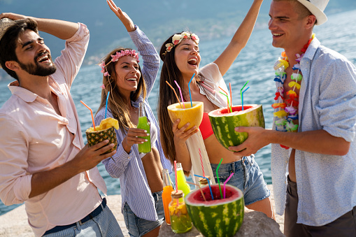 Multiracial group of friends enjoying summer vacation with cocktails. Concept of friendship, celebration and travel