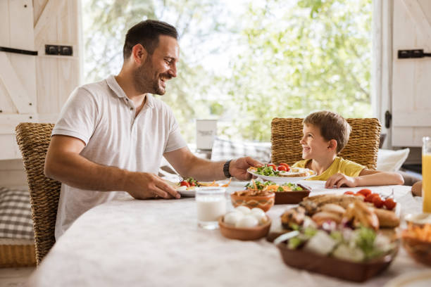 istock Happy single father talking to his boy during breakfast at home. 1742240974