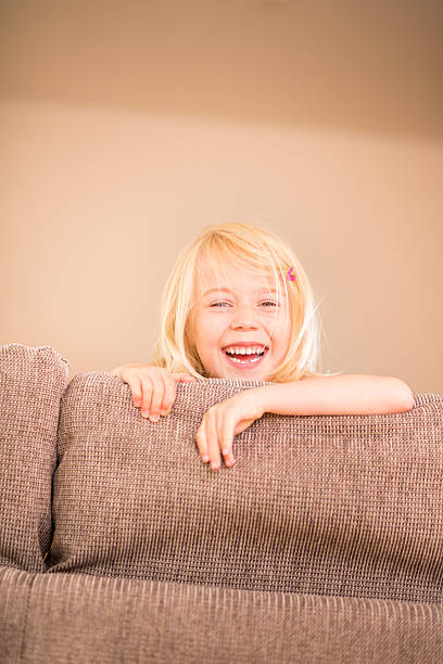 istock Cute girl smiling at camera on sofa 174226020