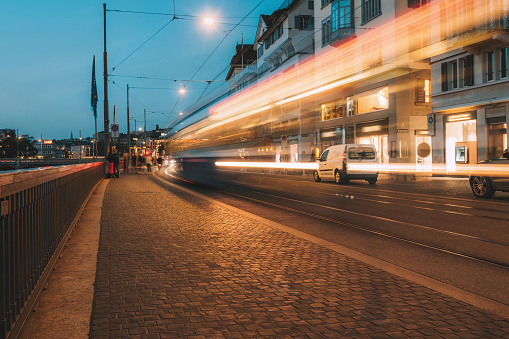 long exposure of yellow cable car on zurich street at blue hour