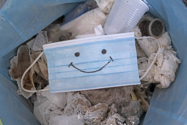 Waste during COVID-19. Discarded disposable coronavirus masks. Environmental waste plastic pollution.