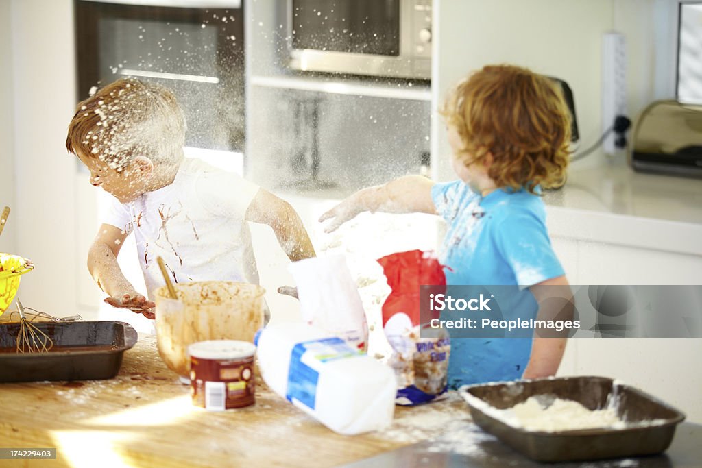 Things are getting out of control in here! Little boys covered in baking ingredients during a messy baking session Child Stock Photo
