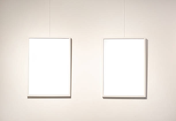 istock Blank picture frames on grey wall with glowing lamp, mock up 1742309190