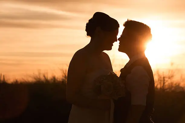 Beautiful same sex couple in civil union at sunset