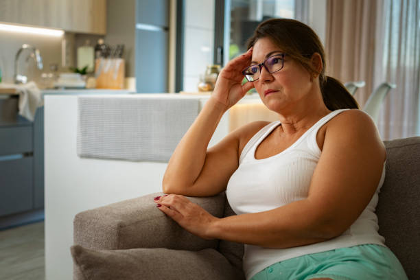 istock Thoughtful mature woman sitting on sofa 1742328214