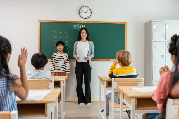 istock Group of student learn with teacher in classroom at elementary school. Attractive beautiful female instructor master explain and educate young children with happiness and fun activity at kindergarten. 1742339883